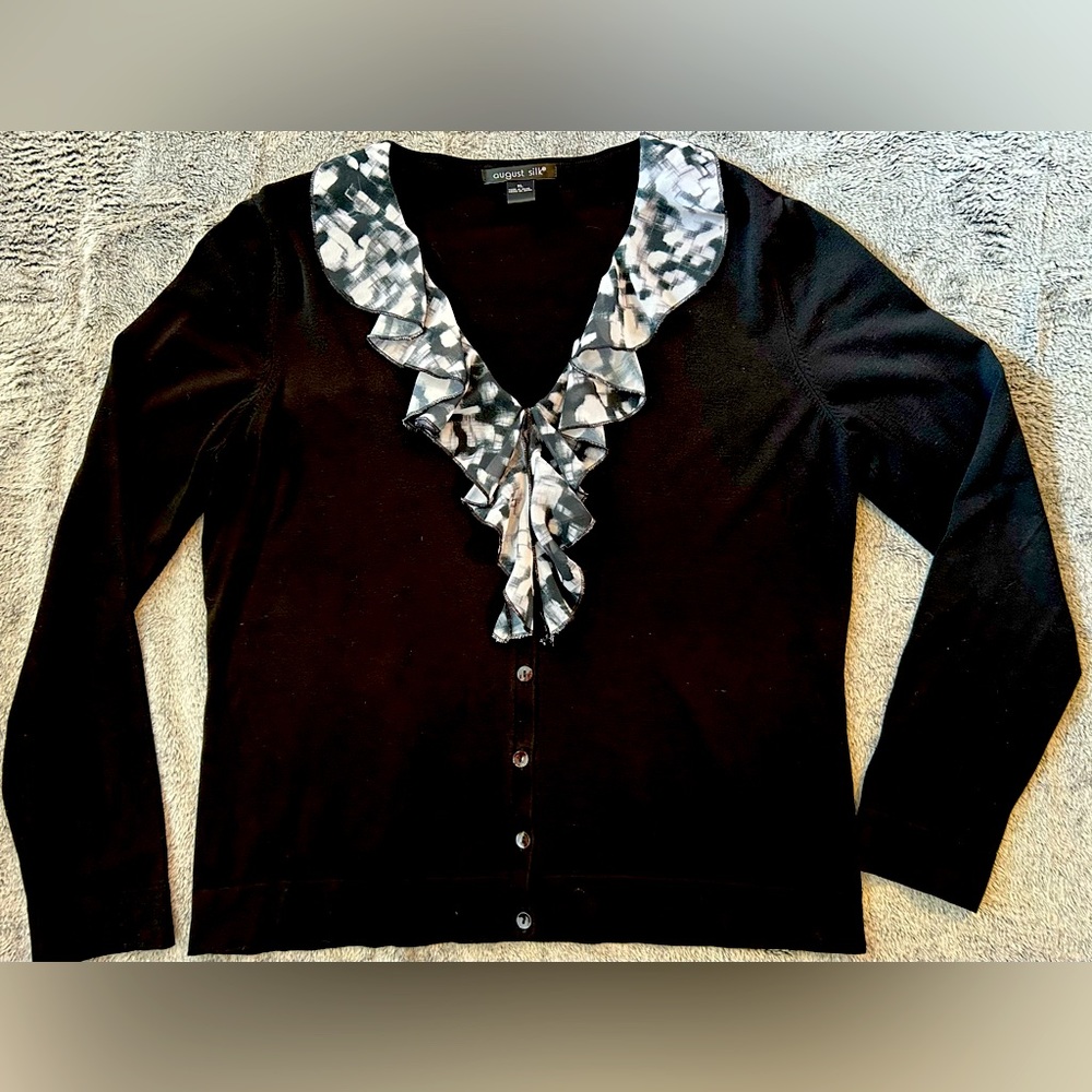 Black V-neck with ruffled front collar.